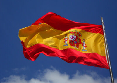 The red and yellow flag of Spain fluttering in the breeze on a blue sky day