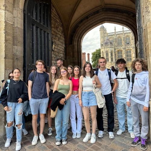 A group of teenage students on a trip to Windsor castle posing for a photo