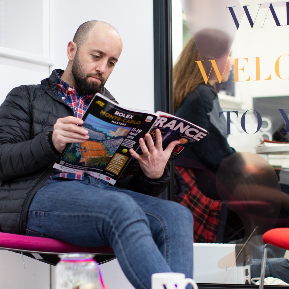 A man reading a magazine about France in the VICI language academy