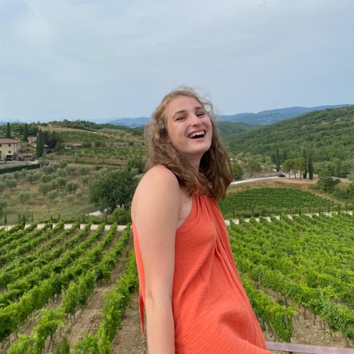 A teenager smiling on holiday in front of the Italian mountains