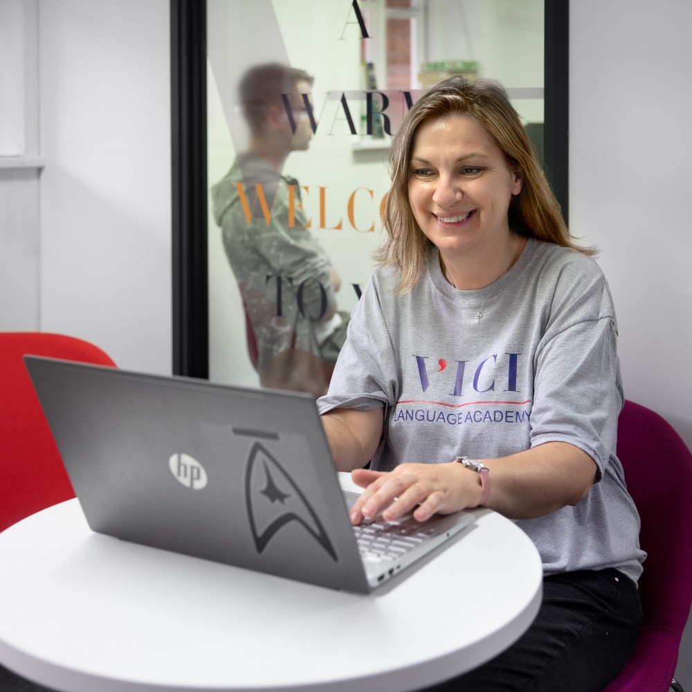 A woman typing on a laptop in the VICI Language Academy