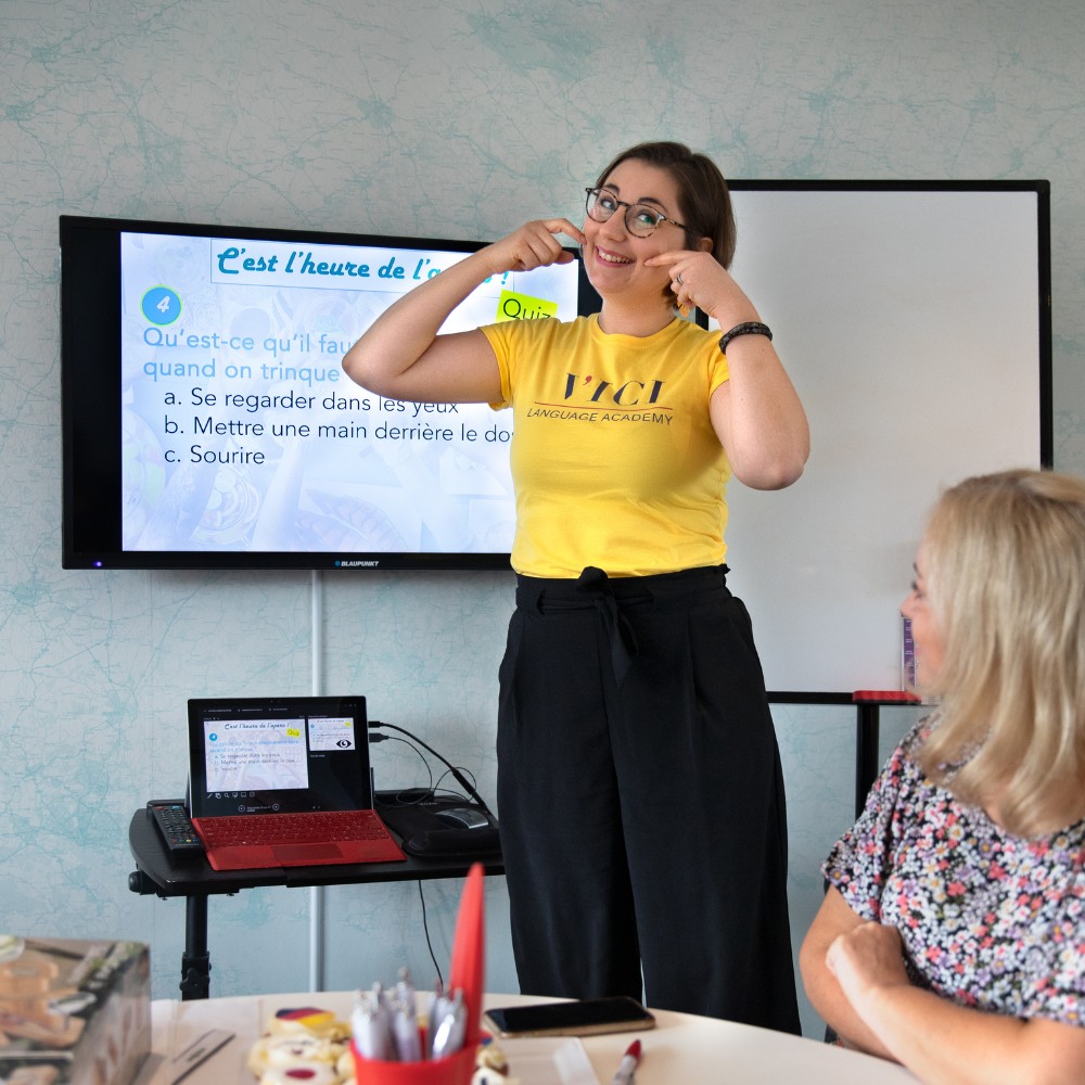 A teacher in a yellow VICI tshirts giving a language class