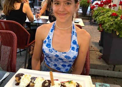 A young girl smilng with a plate of profiteroles