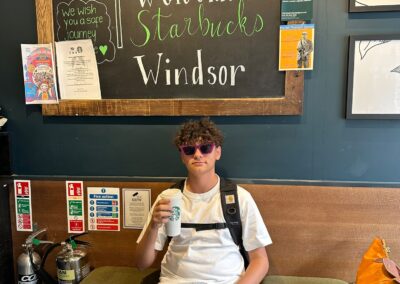 A young boy posing with a coffee in Starbucks, Windsor