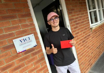 A young student giving the thumbs up outside VICI Academy