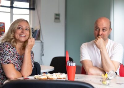 Two smiling adults learning in a bright room