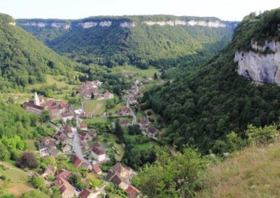 Green landscape with large cliffs and a quaint village