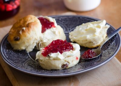 A scone with cream and jam on a blue plate