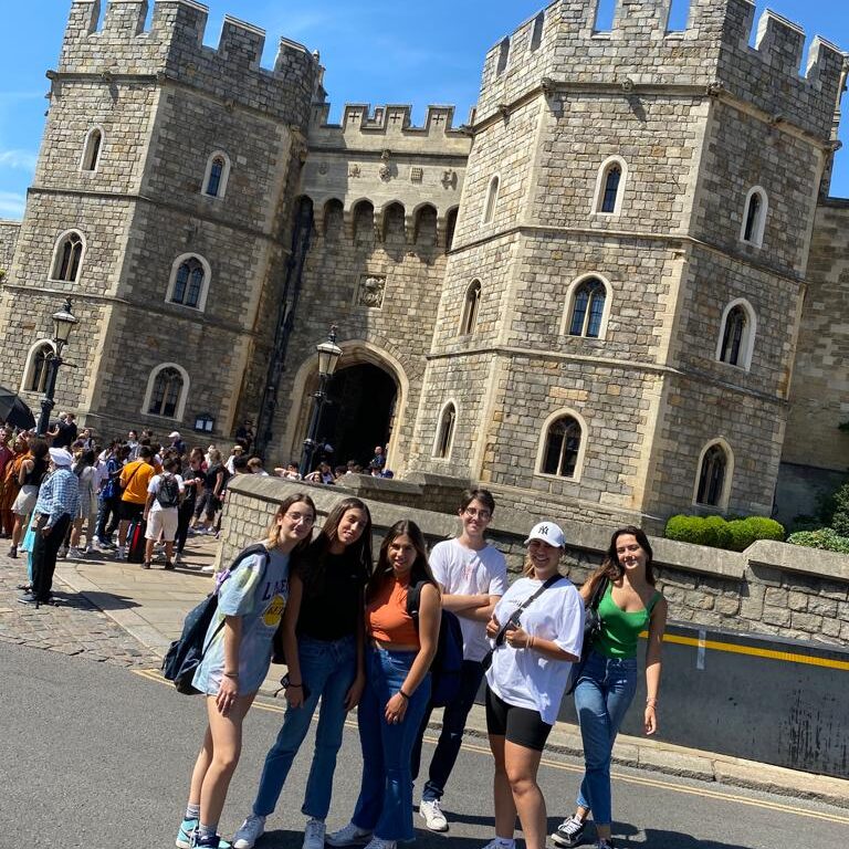A group of young students posing for a photo next to Windsor Castle