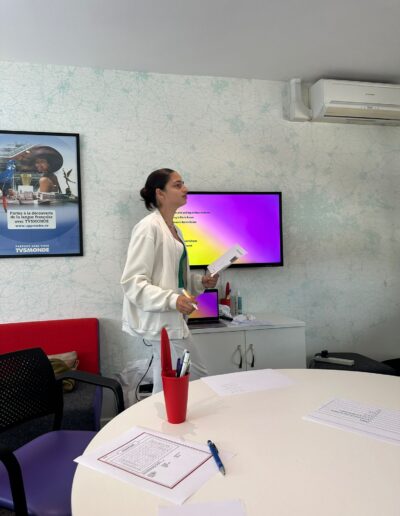 A young teenager teaching a class in front of a purple screen