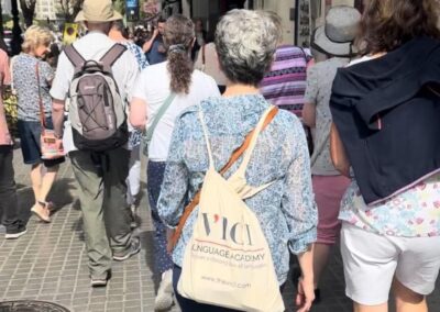 A group of people walking down the street wearing VICI tote bags