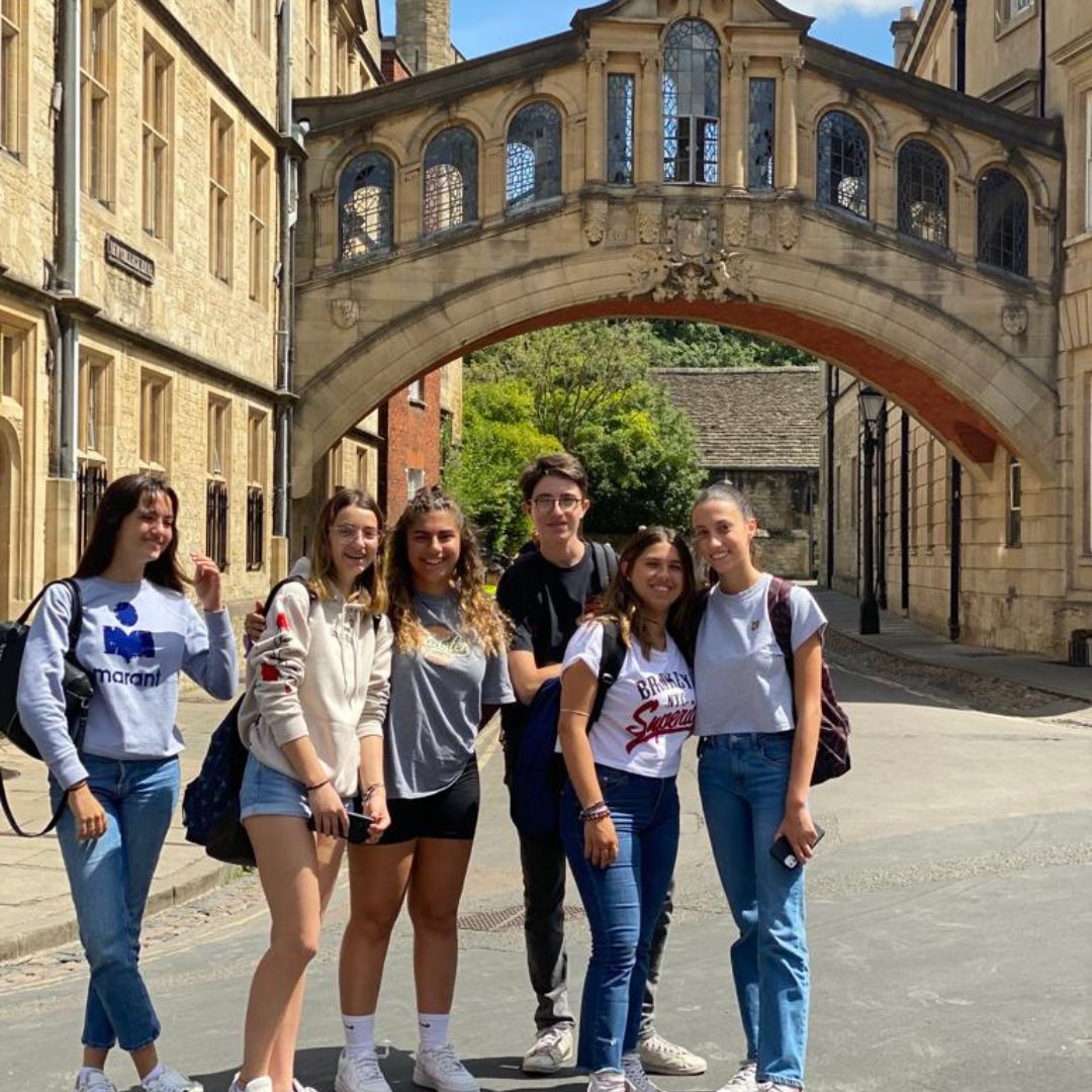VICI Programmes A group of young students smiling in front of the Bridge of Sighs, Oxford on a summers day