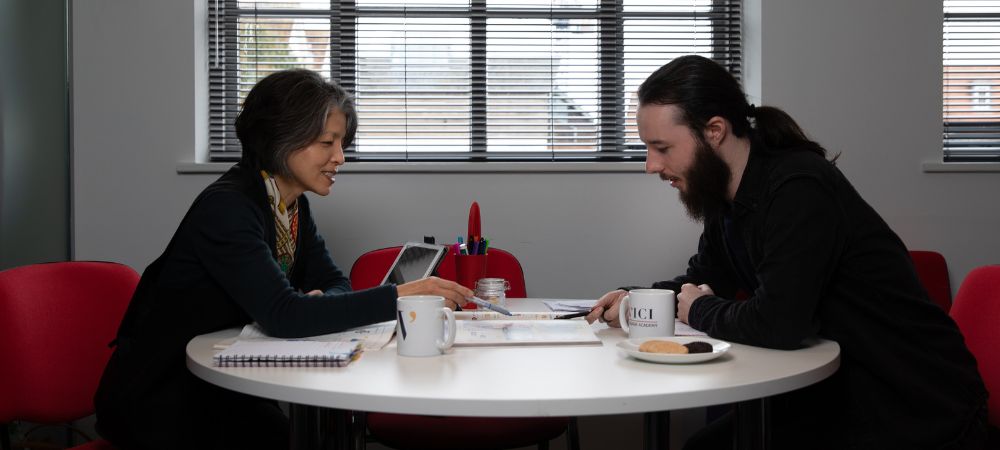 A language teacher giving two people a lesson in a classroom