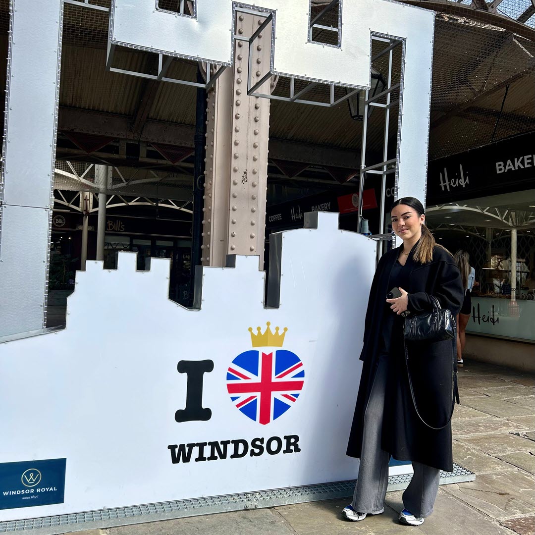 A young girl wearing a green top posing outside Windsor castle